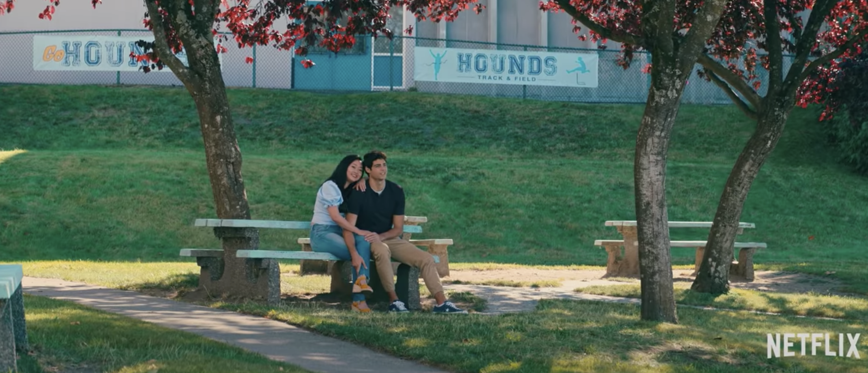 Lara Jean and Peter sitting at a table outside at their high school