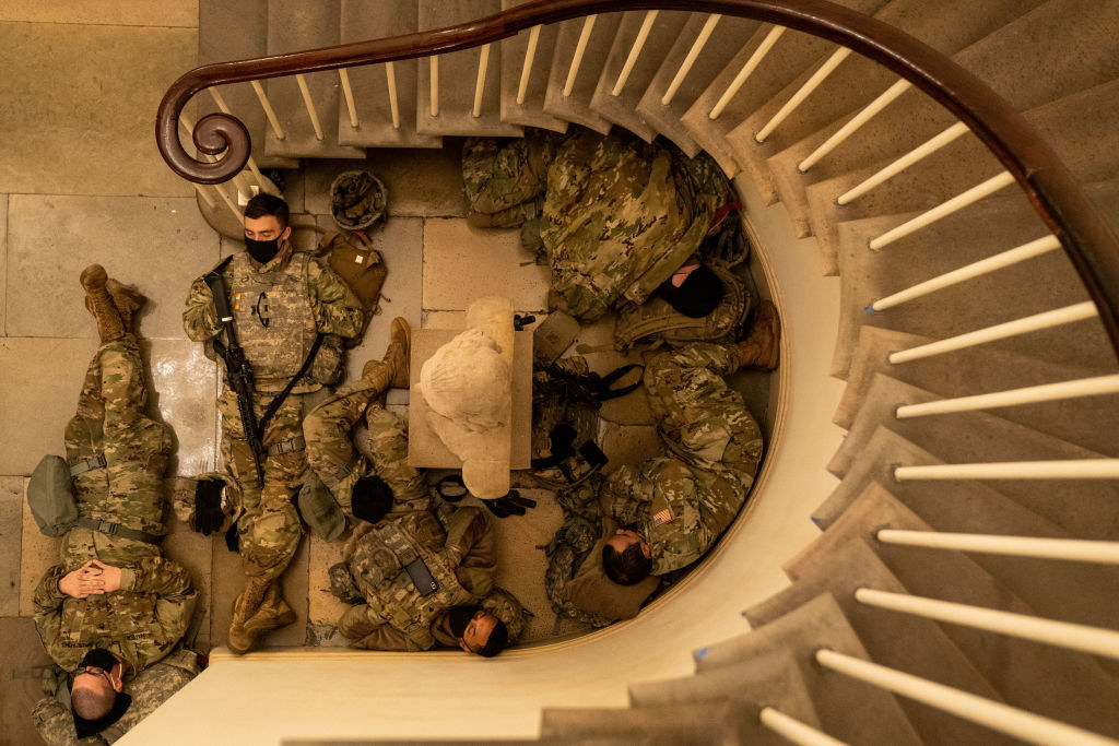 An overhead shot of National Guard members sleeping in the nook of a stairwell inside the Capitol