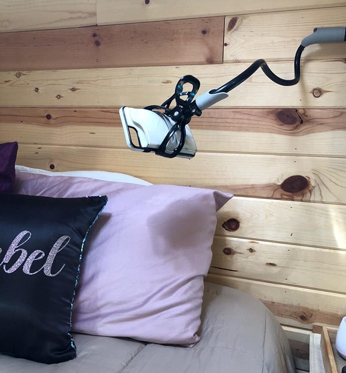 reviewer image of the gooseneck phone mount attached to a headboard