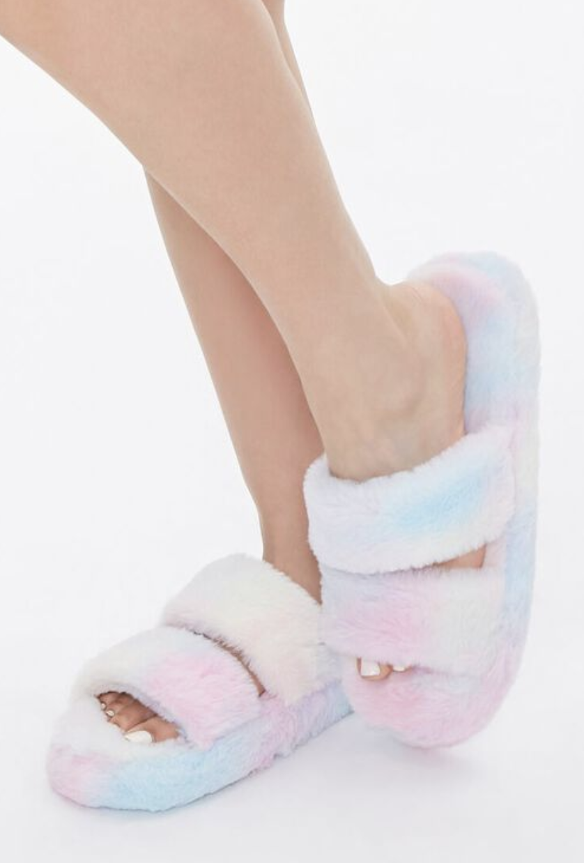 Model in faux fur pastel tie dye slippers with open toes 