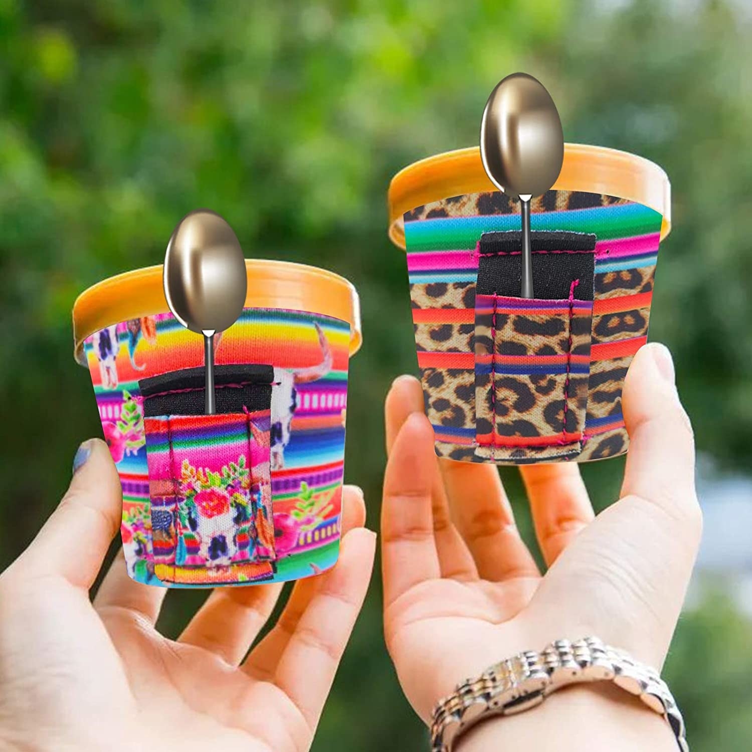 A pair of hands holding two small tubs of ice cream dressed in the neoprene cozies