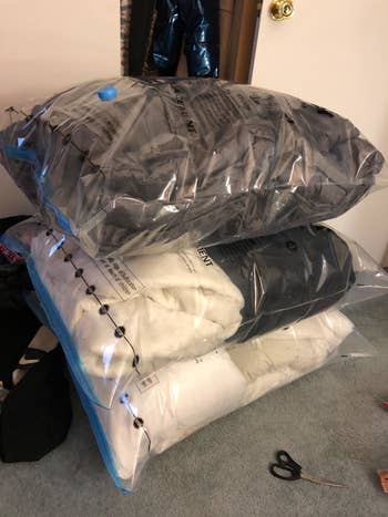Reviewer photo of comforters and pillows in pre-flattened jumbo space saver bags