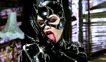 GIF of Michelle Pfeiffer as Catwoman licking herself