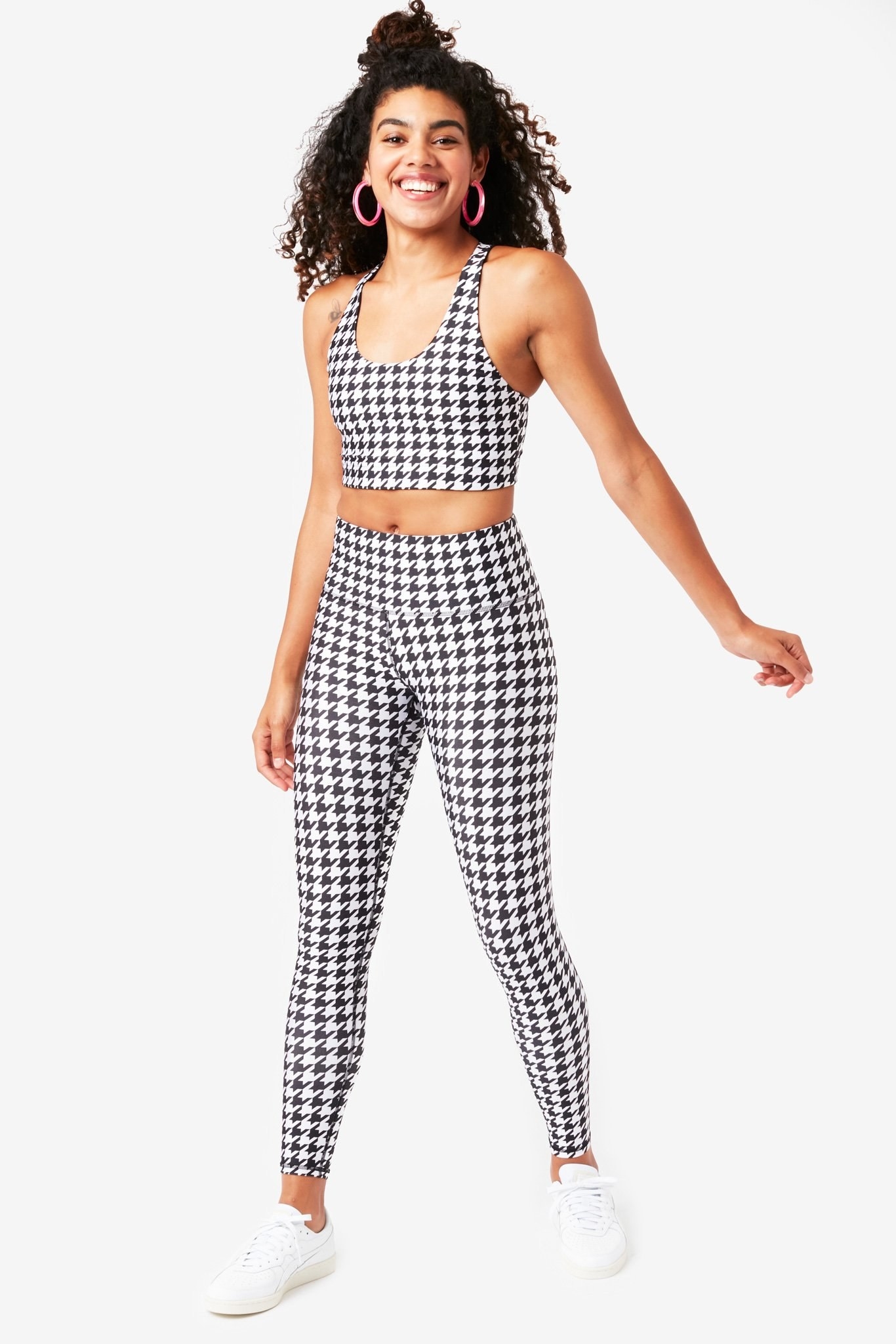 model wearing the sports bra and leggings in black and white houndstooth pattern