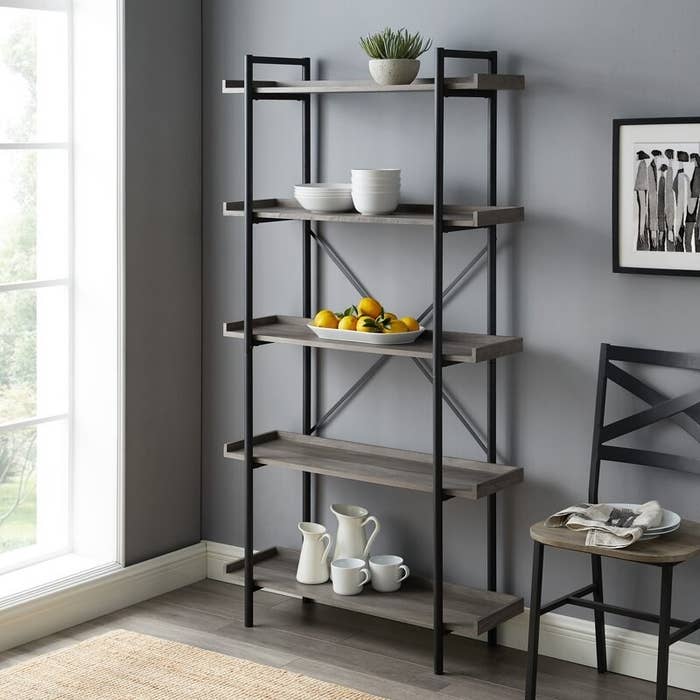 The bookcase in gray, with five gray wood shelves, and black pipe-style metal framework