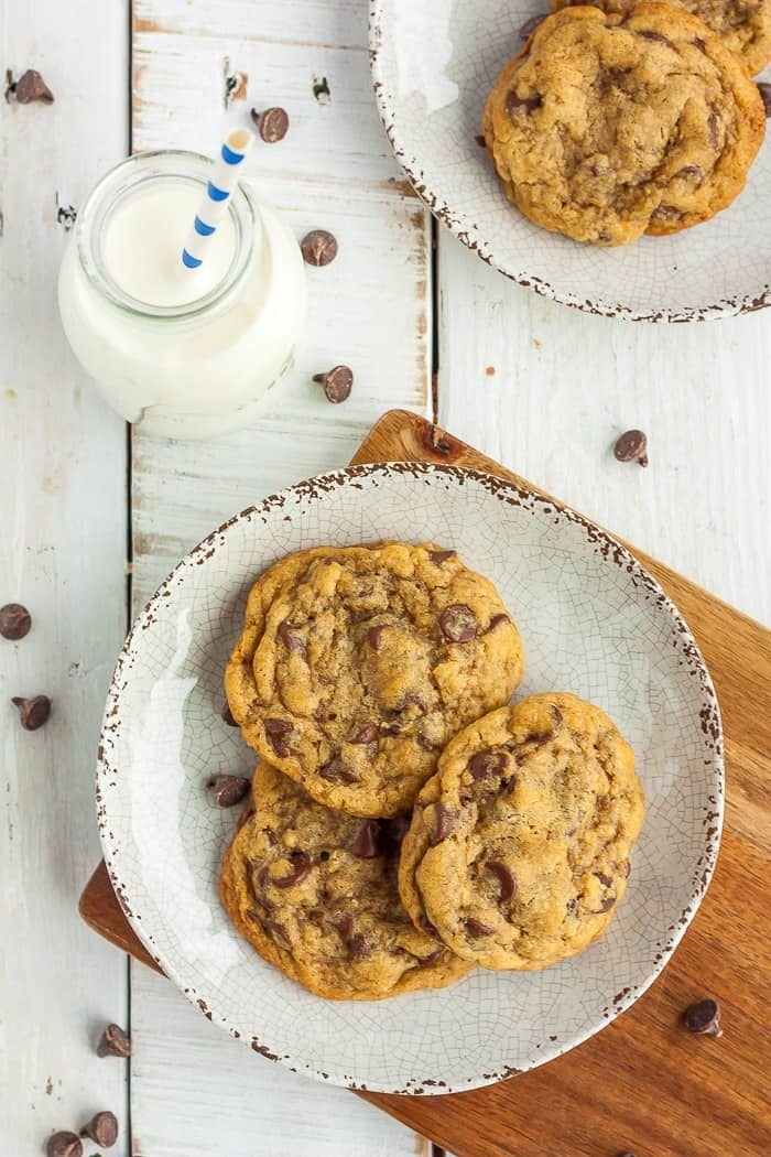 Air fried chocolate chip cookies on a plate with a glass of milk.