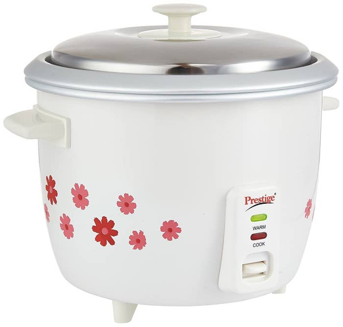 A white rice cooker with floral prints on the side