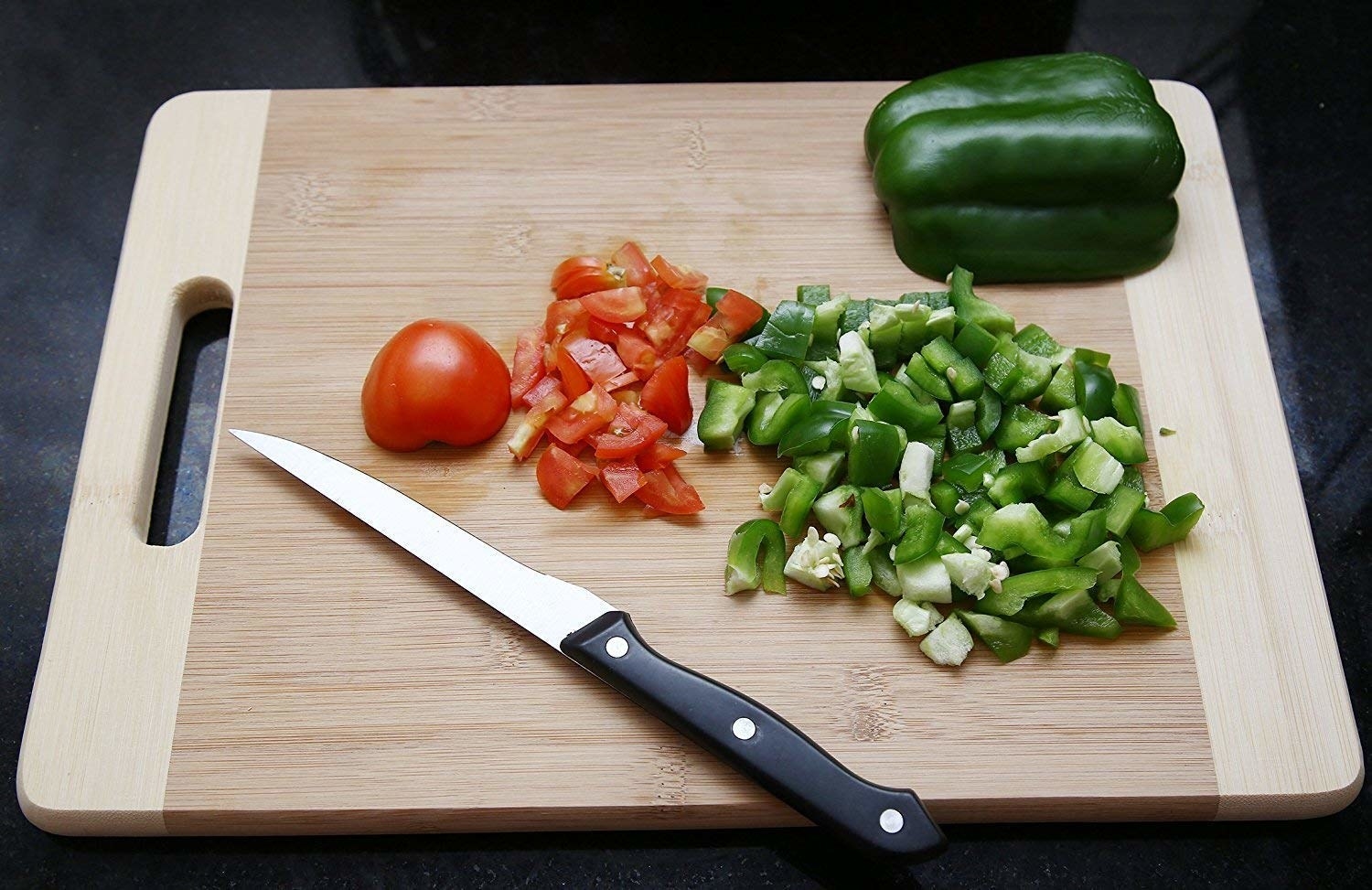 A bamboo chopping board with cut vegetables