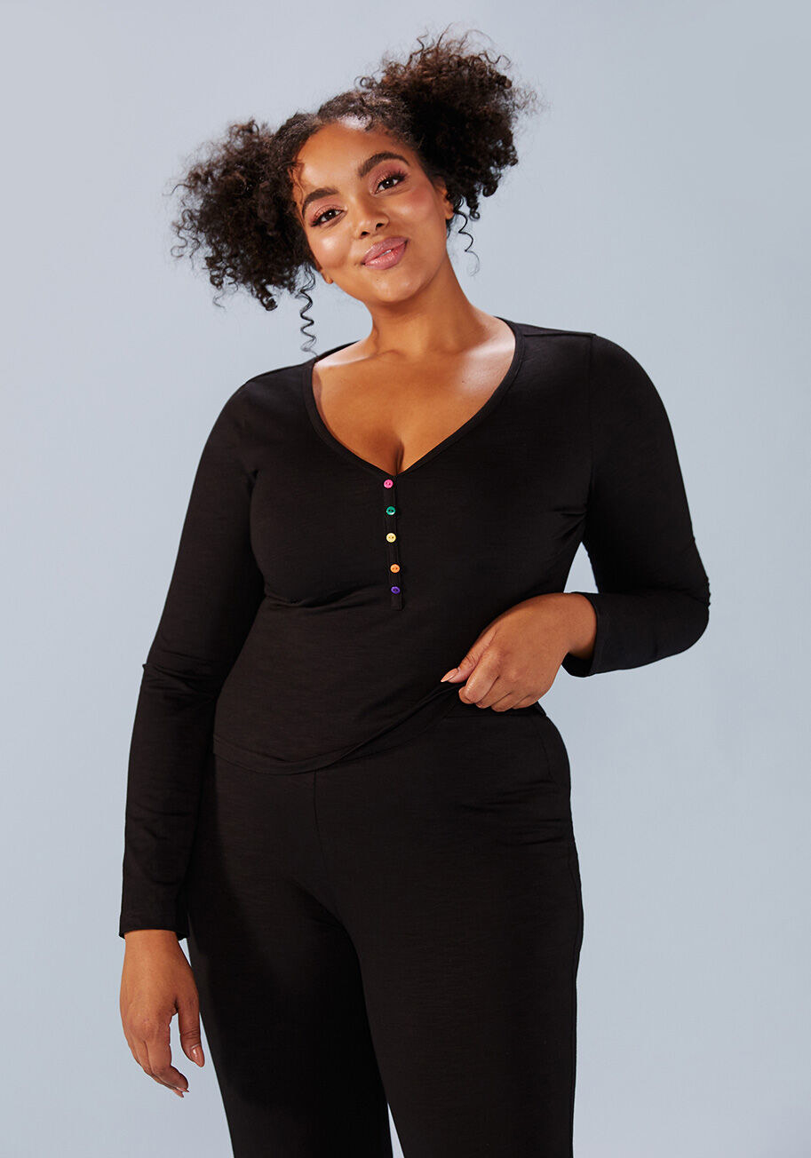 a model wearing the black loungewear with brightly-colored buttons