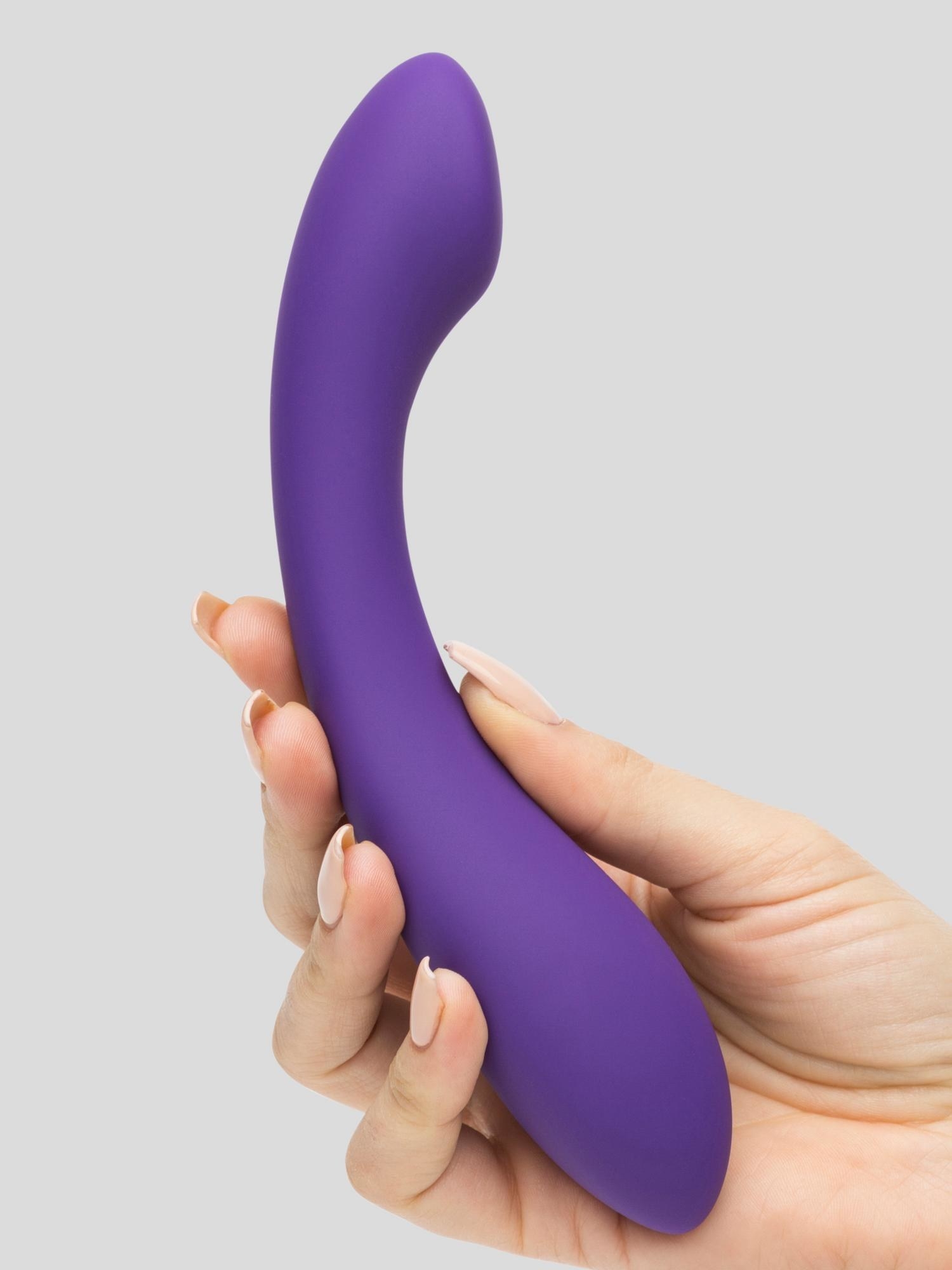 a hand holding the curved purple toy