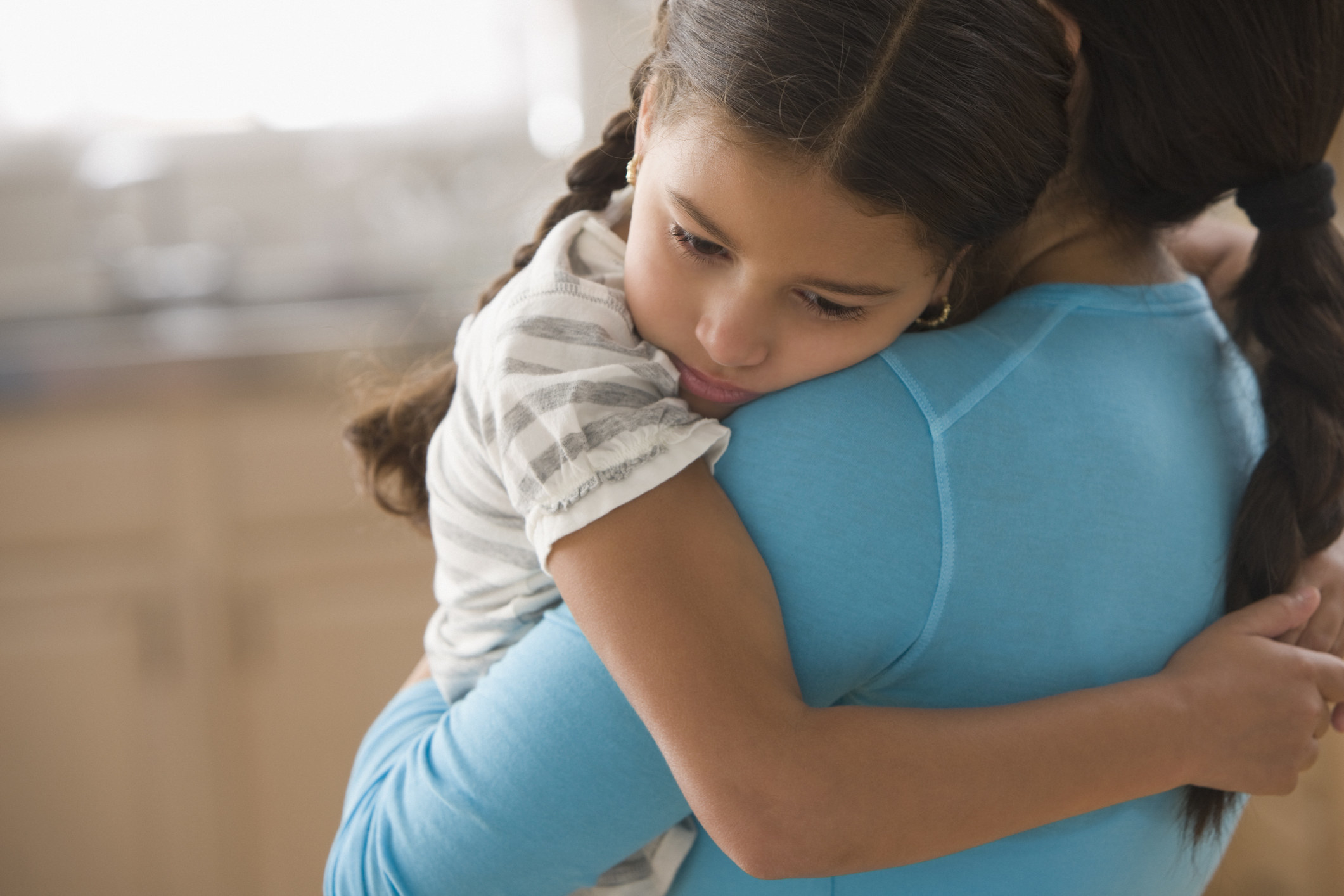 Mother hugging sad daughter
