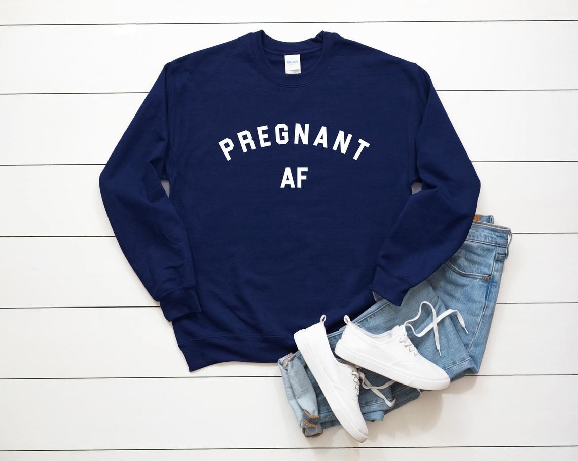 The crewneck next to a pair of jeans and sneakers