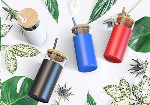 Four tumblers of various colours on a leafy backdrop