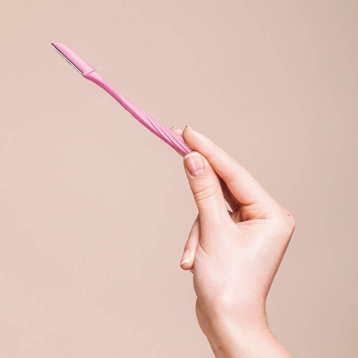 A person holding up one of the skinny facial razors