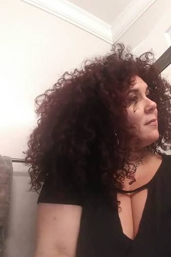 A woman showing her curly hair after using the blow dryer diffuser 