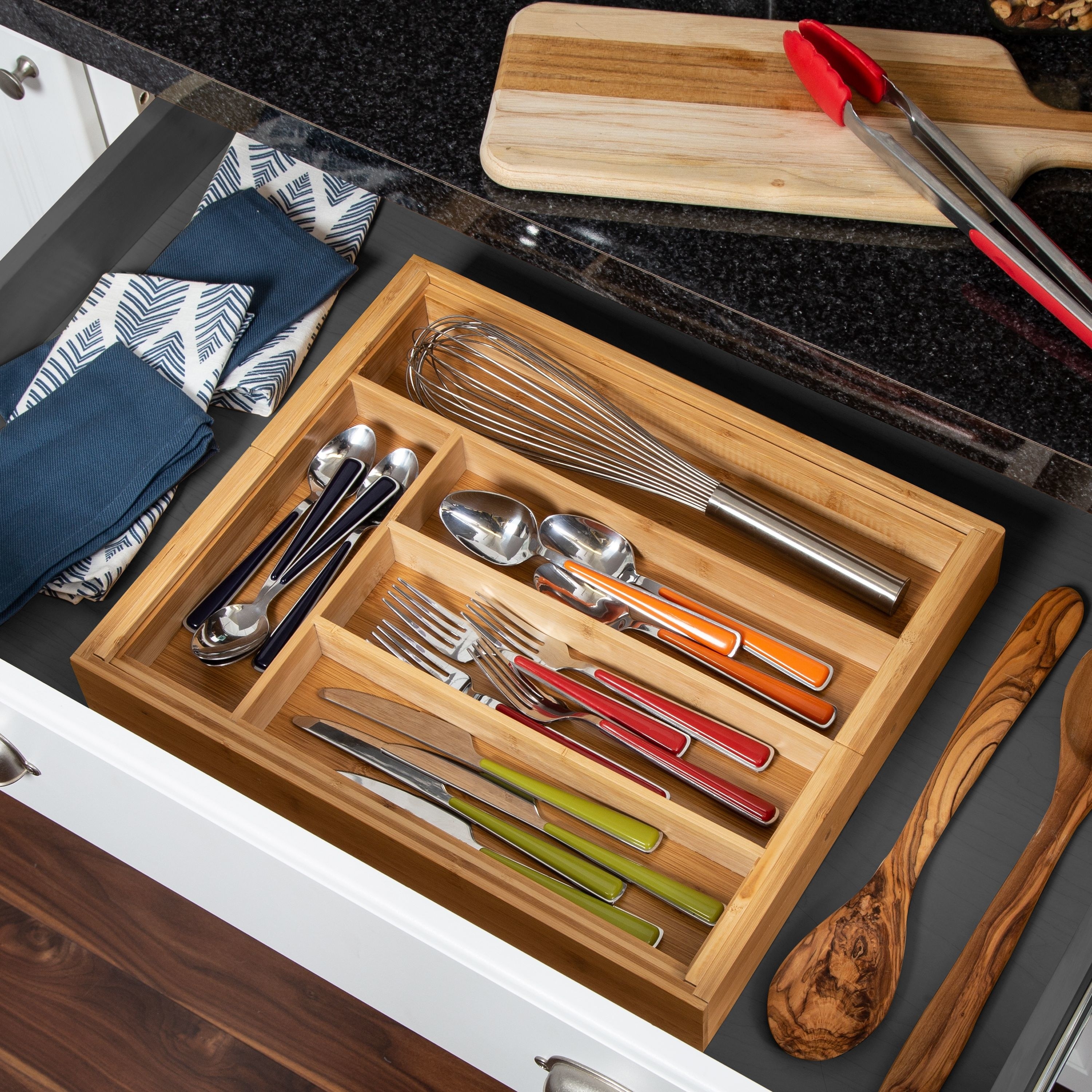 bamboo drawer organize inside a drawer and holding different utensils