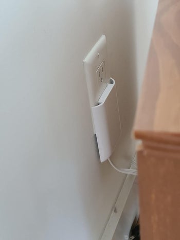 A reviewer's photo of the outlet being used behind furniture
