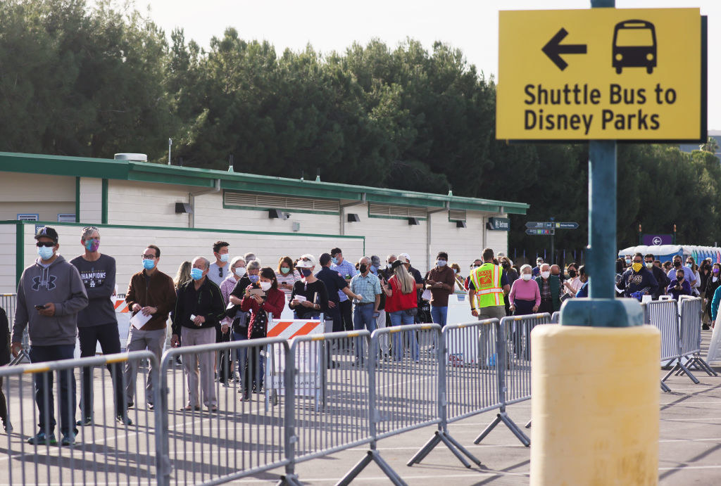 the line stretches past the sign for the shuttle buses