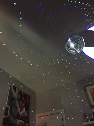 Reviewer with large disco ball on ceiling, the light hitting it causes dots to hit the walls around the room 