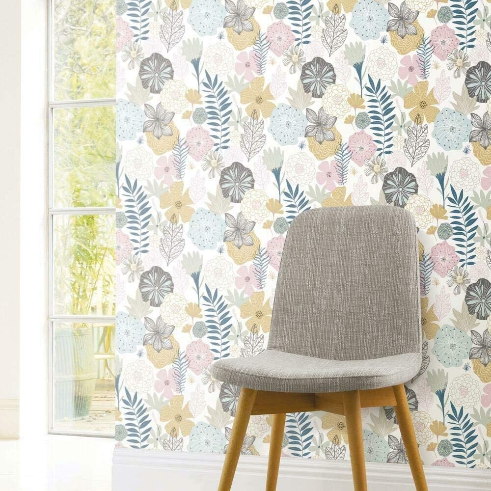 A stylish chair in front of the floral wallpaper