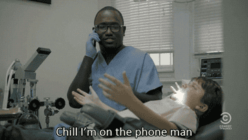 Dentist talks on the phone while with a patient