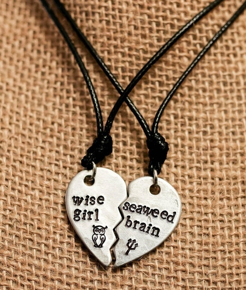 The silver half heart pendants on black cords that fit together. One says "Wise girl" with an owl symbol and the other "Seaweed brain" with a trident