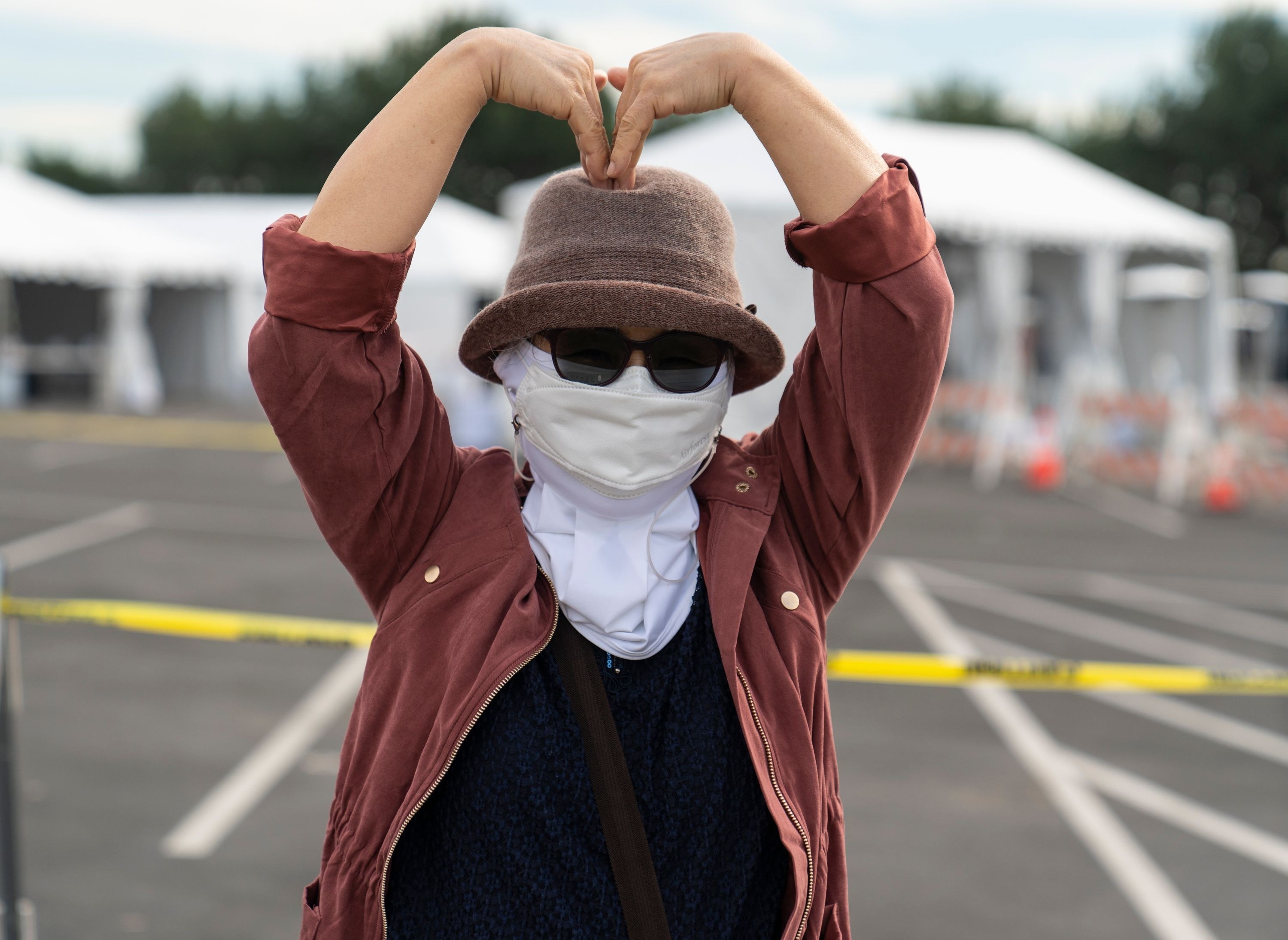 a woman makes a heart with her arms outside the distribution site