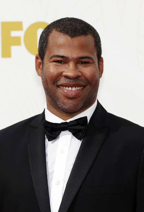 Jordan Peele smiling, wearing a black tux with a bow-tie