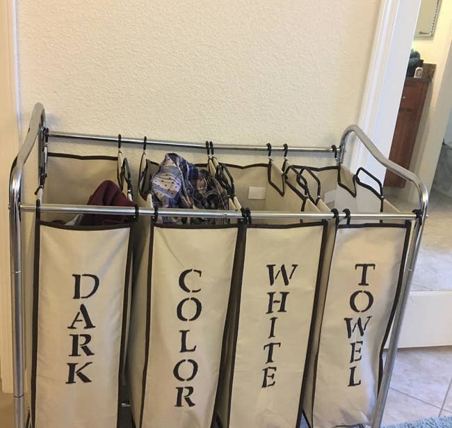 reviewer photo showing laundry organizer that they stenciled with the words dark, color, white, and towel 