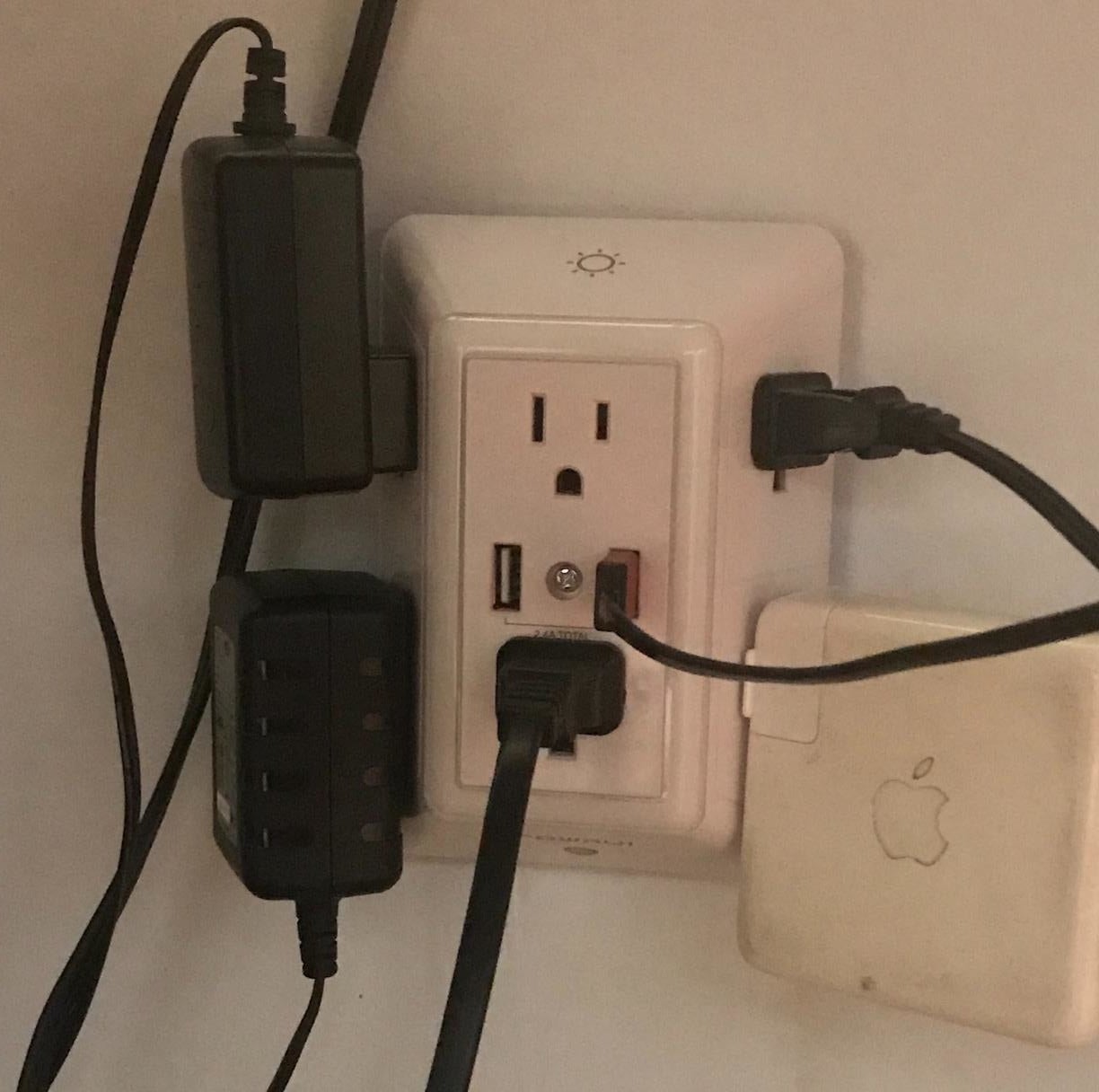 The three-sided wall adaptor with a range of different devices plugged in 