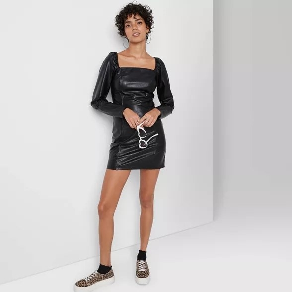 model wears faux leather mini dress with a square neck 