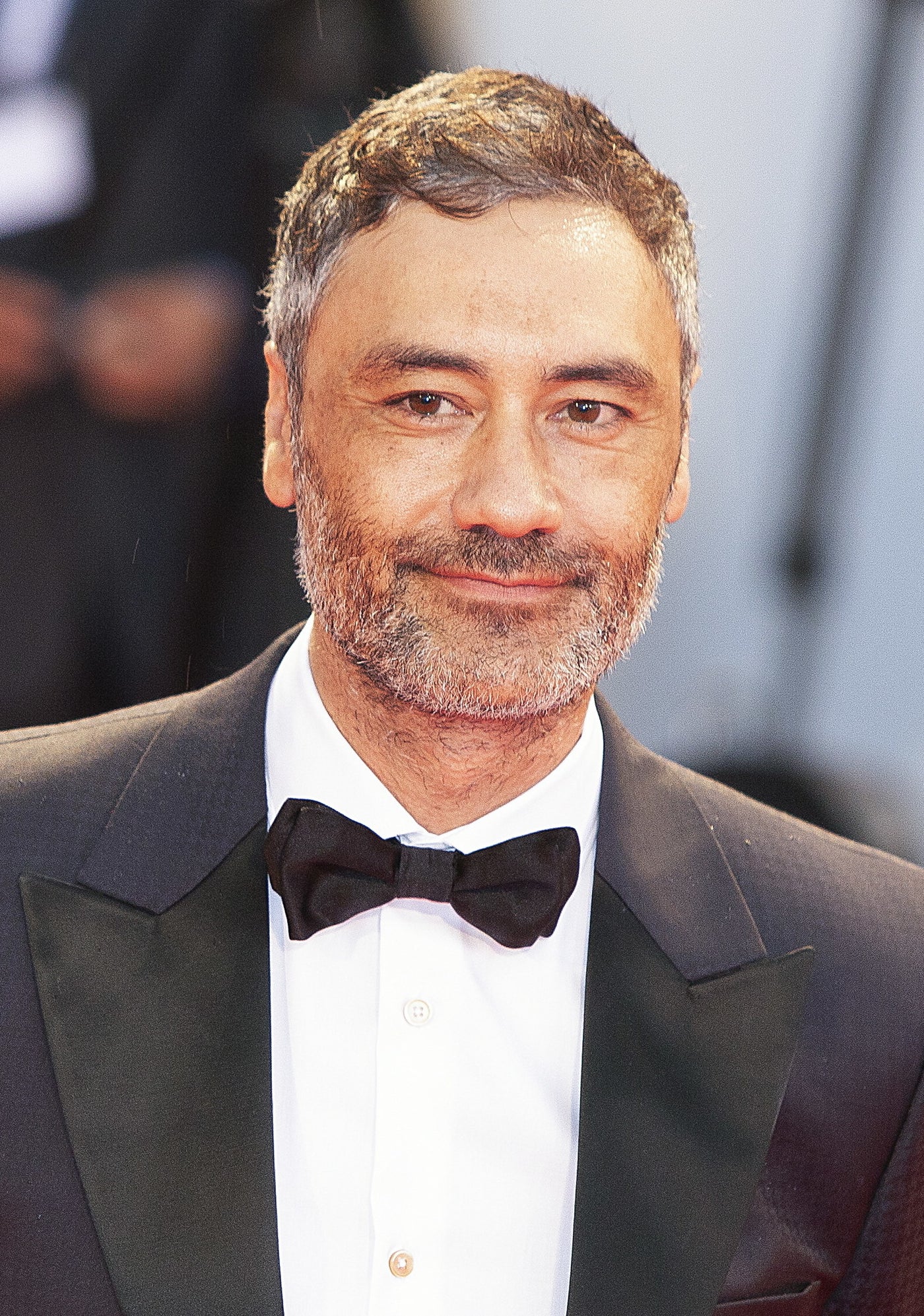 Taika Waititi in a suit with a bow-tie