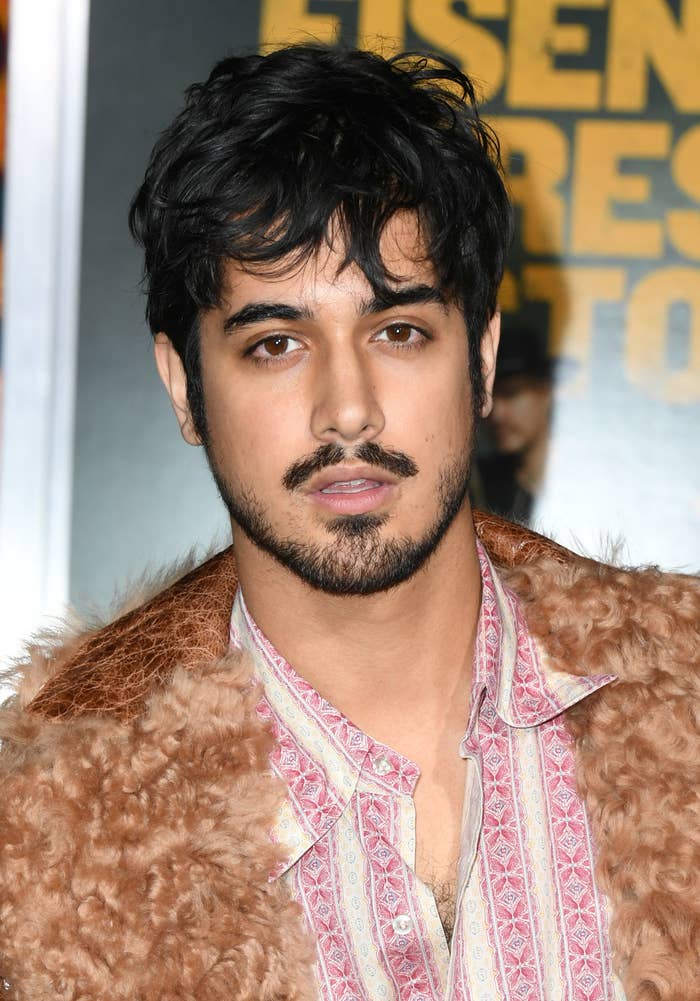 Avan Jogia with short hair wearing a teddy coat and button down shirt