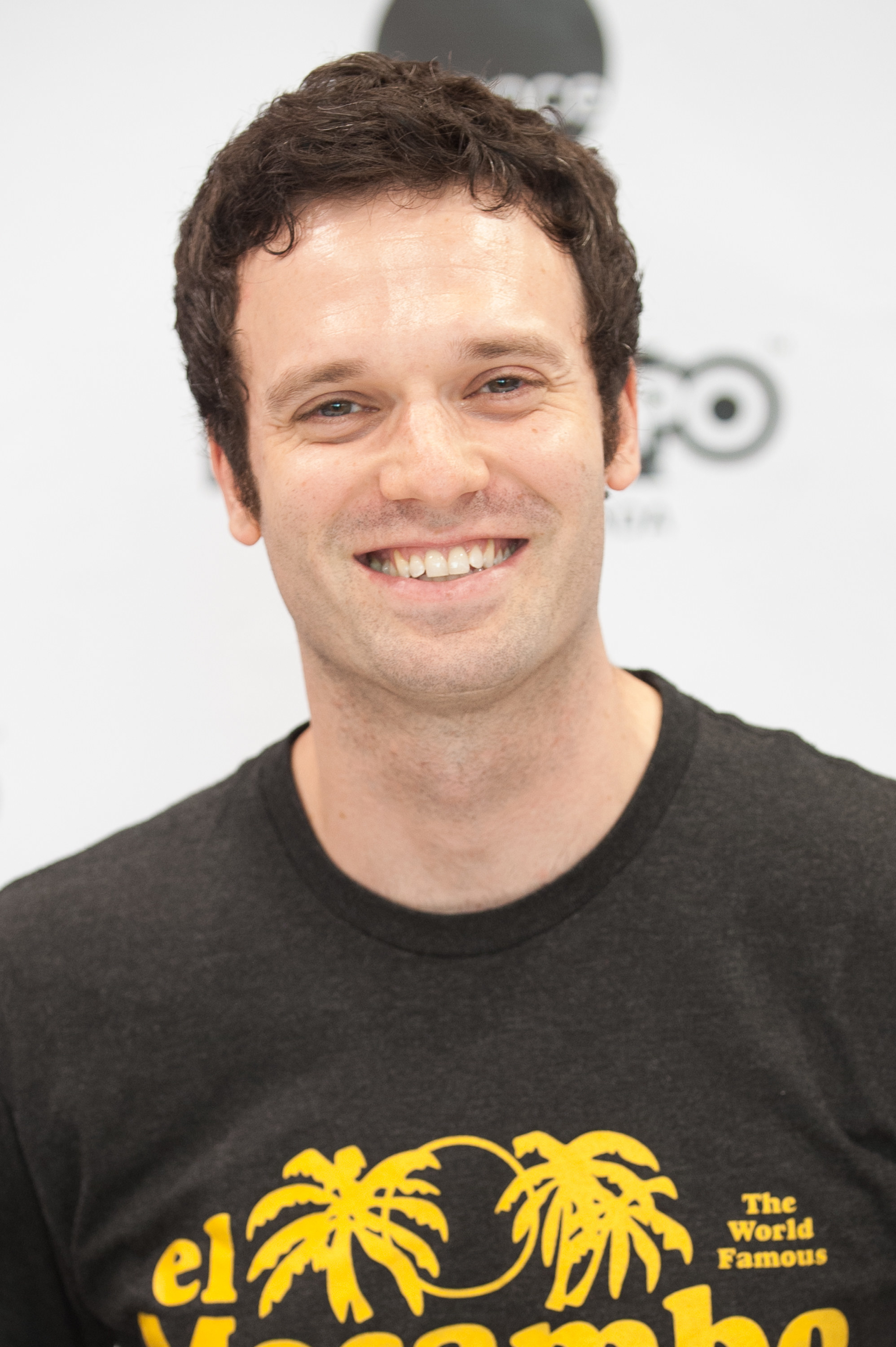 Jake Epstein posing in a black t-shirt