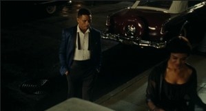 A man stands in front of a woman stoop as she walks up her steps.