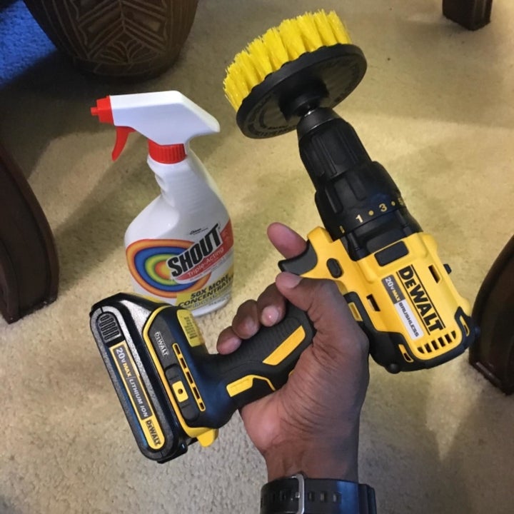 Reviewer holding drill with brush attachment