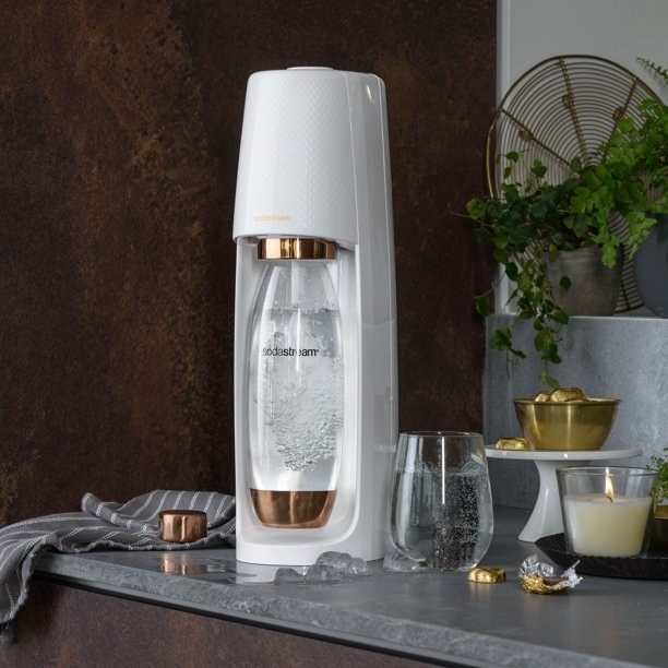 a white sodastream water maker with rose gold accents