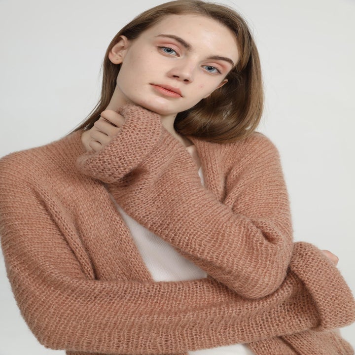 Zoomed in shot of a model wearing the cardigan which has cuffed sleeves 