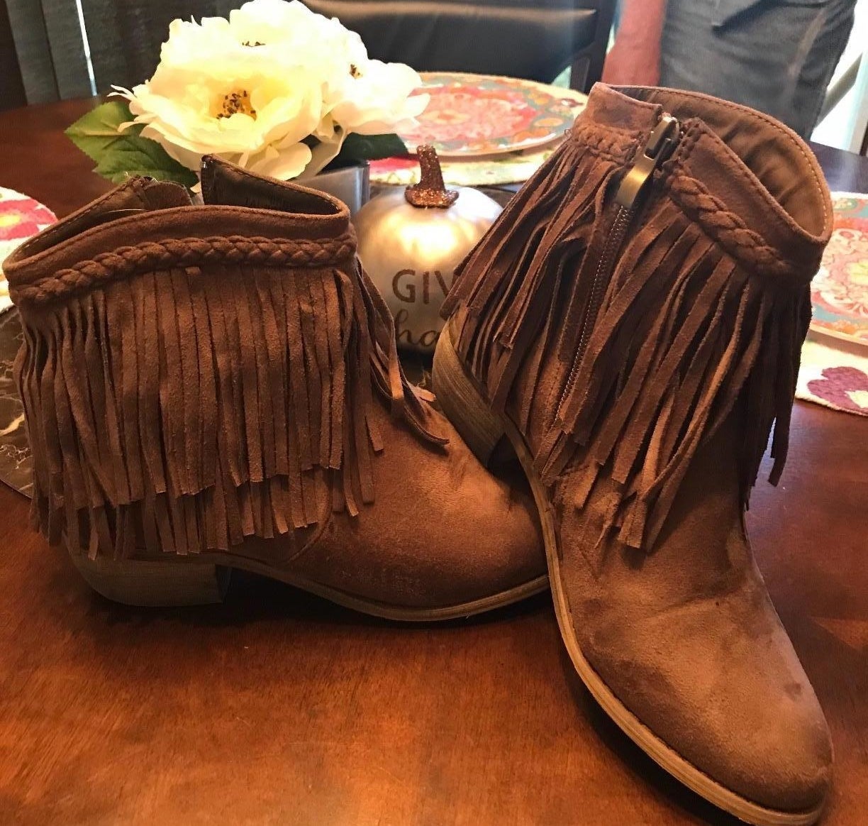 reviewer images of the booties with two layers of fringe around the ankle in brown