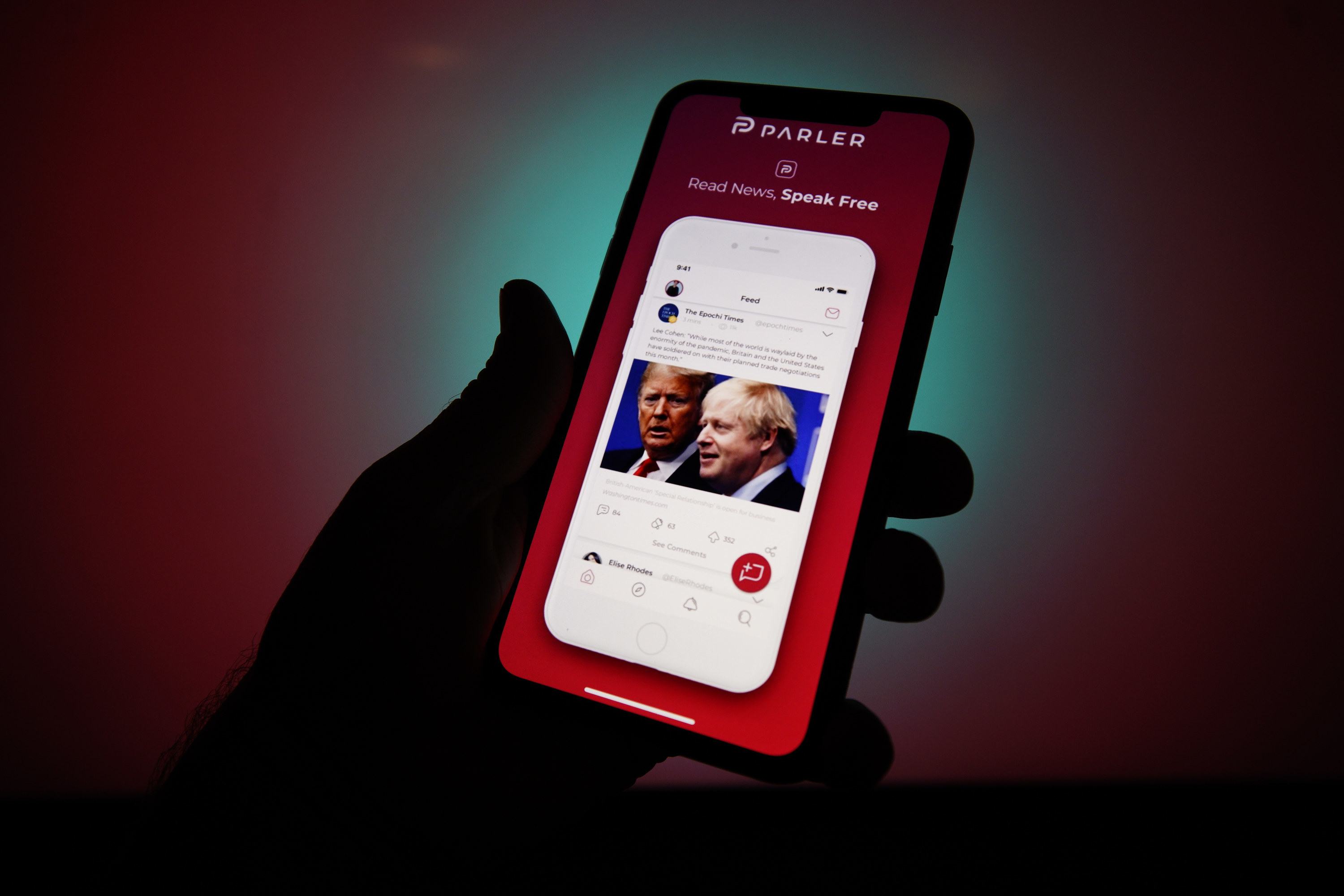 A person holding a smartphone with the Parler app