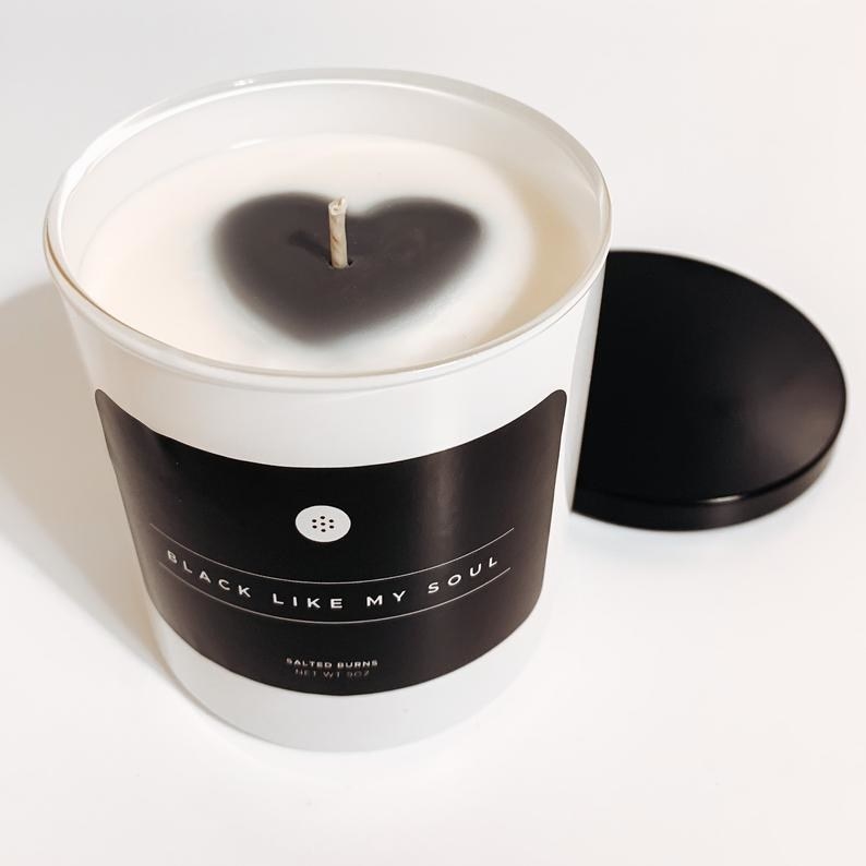 a candle with a black label that says black like my soul and black heart around the wick 