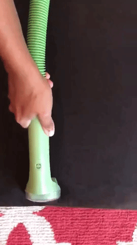 GIf of Amazon reviewer using Bissell Little Green machine on black fabric