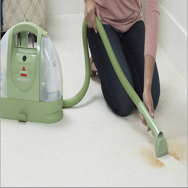Model using Bissell Little Green cleaner on carpet