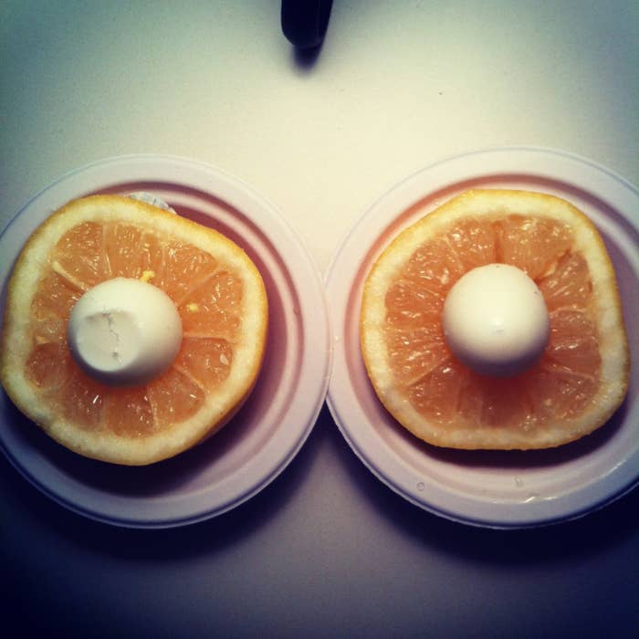 Two slices of grapefruit with half of a hardboiled egg on them