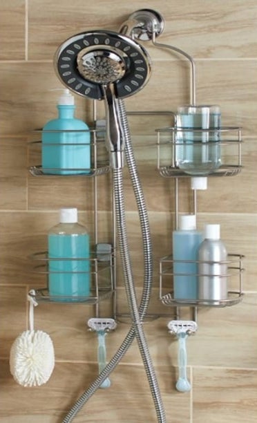 silver adjustable shower caddy in a shower holding bottles, sponge, and razors