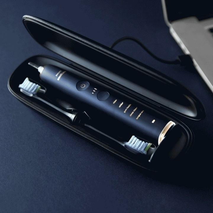 The toothbrush and two replacement heads inside the portable charging case