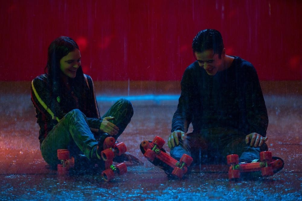 Marcus and Wendy sitting on the floor of a wet roller rink