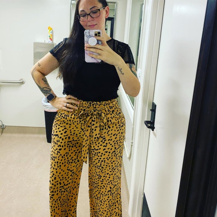 A reviewer wearing the pants in khaki and navy dot