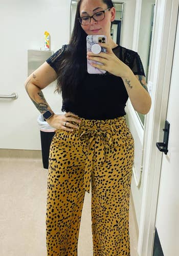A reviewer wearing the pants in khaki and navy dot