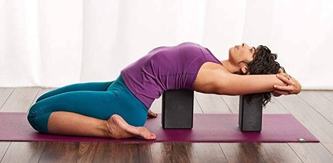 Woman stretching using the yoga blocks.